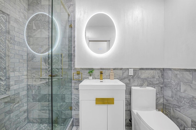 bathroom featuring tiled shower, vanity, tile walls, and toilet