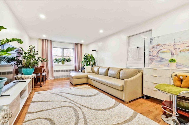 living room featuring radiator heating unit and light hardwood / wood-style flooring