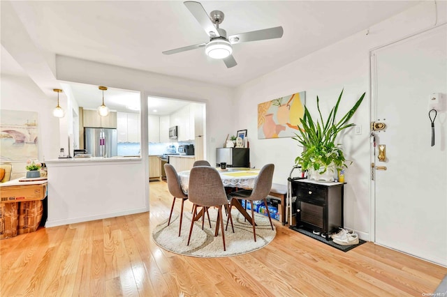 dining room with ceiling fan and light hardwood / wood-style floors