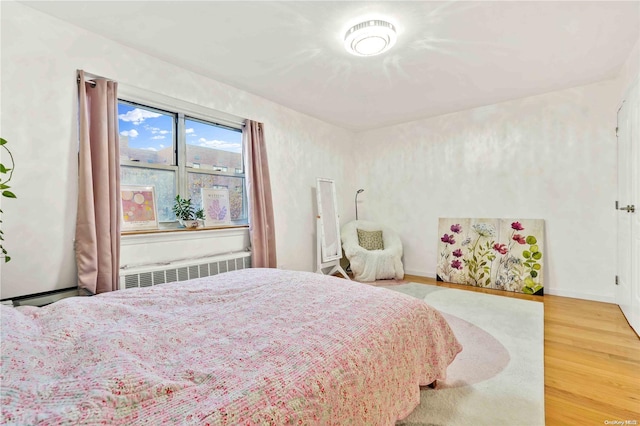 bedroom with radiator and wood-type flooring