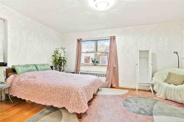 bedroom featuring light wood-type flooring and radiator