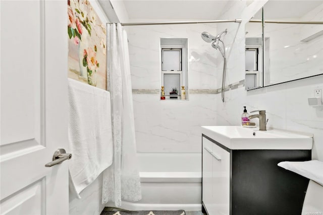 bathroom with tasteful backsplash, shower / bath combo with shower curtain, vanity, and tile walls