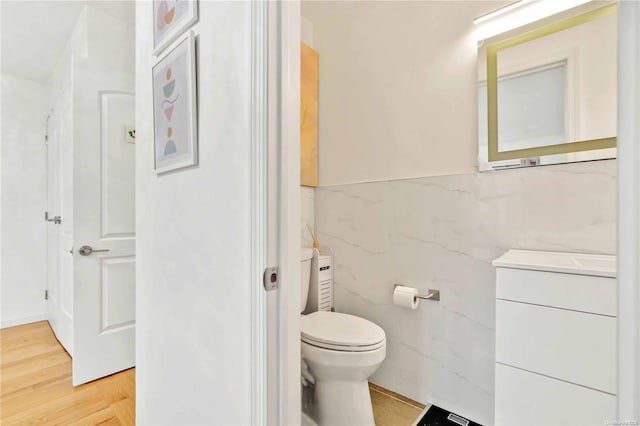 bathroom with vanity, hardwood / wood-style flooring, toilet, and tile walls