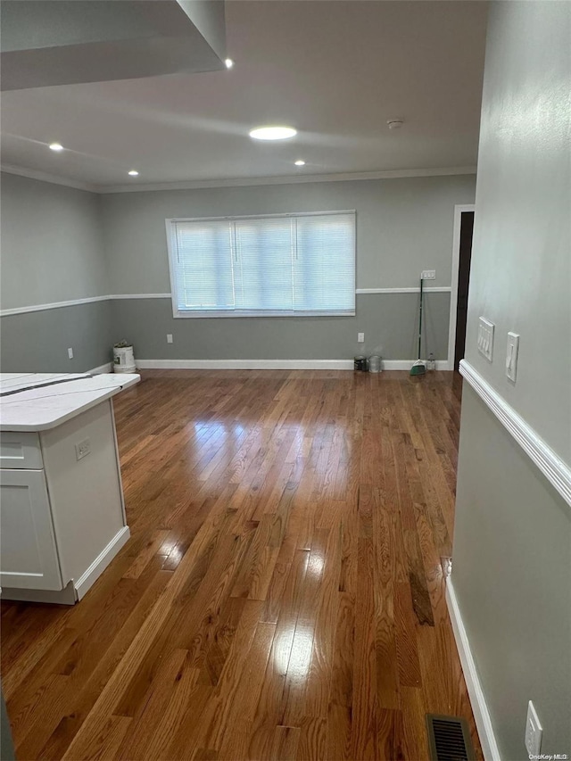 interior space with hardwood / wood-style floors and crown molding