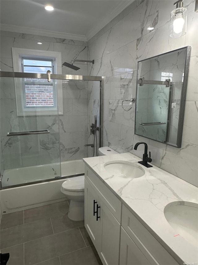 full bathroom featuring crown molding, vanity, tile walls, and combined bath / shower with glass door