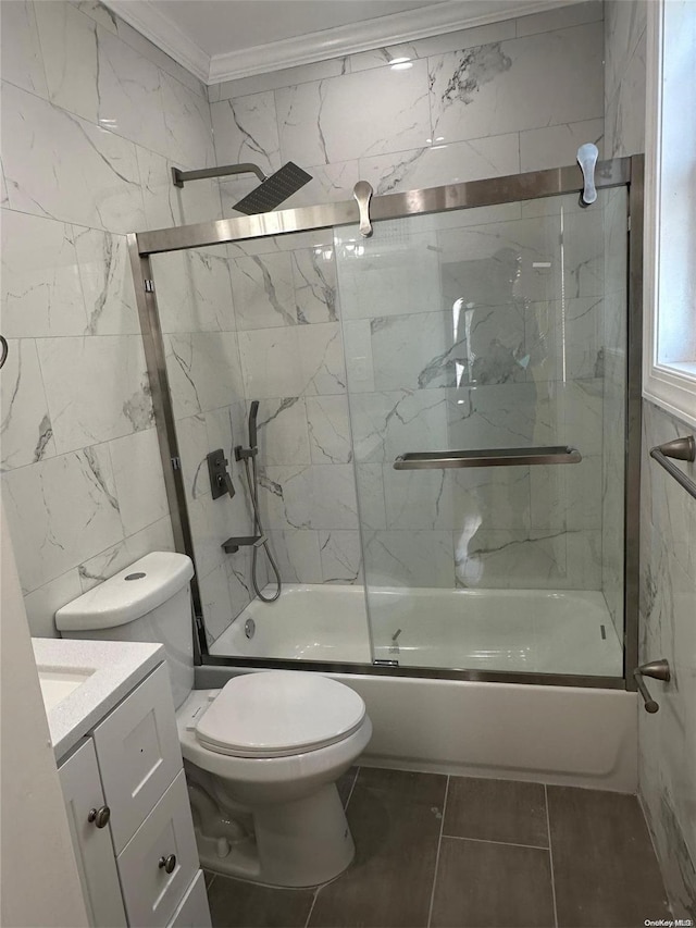 full bathroom with combined bath / shower with glass door, vanity, crown molding, tile walls, and toilet