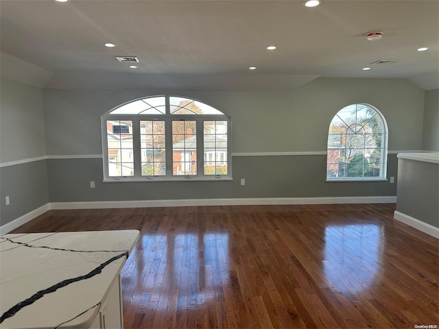 spare room with vaulted ceiling and dark hardwood / wood-style floors