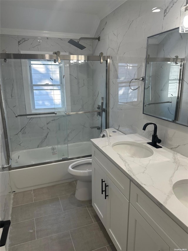 full bathroom with combined bath / shower with glass door, vanity, plenty of natural light, and tile walls