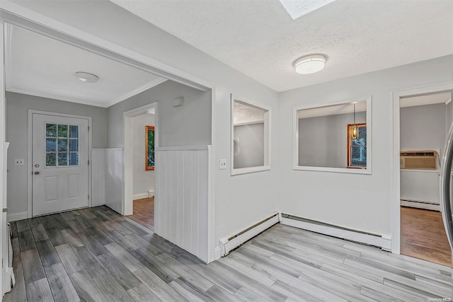 foyer entrance with a textured ceiling, a baseboard radiator, light hardwood / wood-style flooring, and crown molding