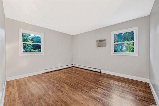 unfurnished room featuring wood-type flooring, an AC wall unit, and a baseboard radiator