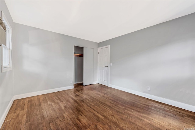 unfurnished bedroom featuring dark hardwood / wood-style floors and a closet