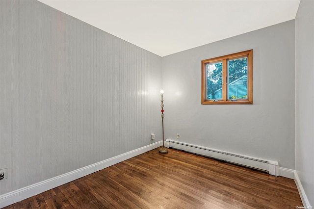 empty room with wood-type flooring and baseboard heating