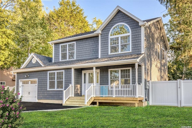 view of front of home with a front yard, a porch, and a garage