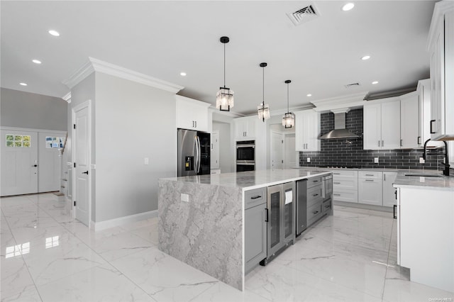 kitchen with white cabinets, a spacious island, wall chimney range hood, appliances with stainless steel finishes, and beverage cooler