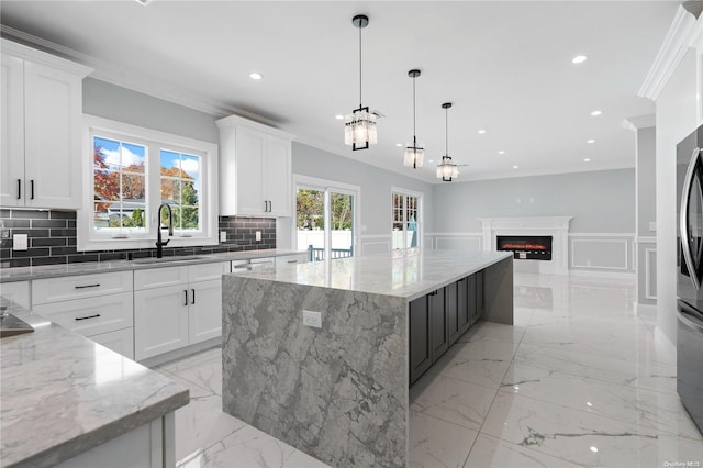 kitchen featuring a large island, white cabinetry, light stone countertops, and sink