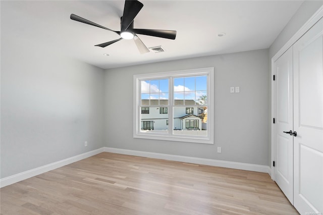 unfurnished bedroom featuring ceiling fan, a closet, and light hardwood / wood-style flooring