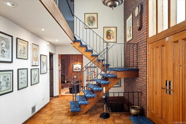 stairs with parquet floors and brick wall