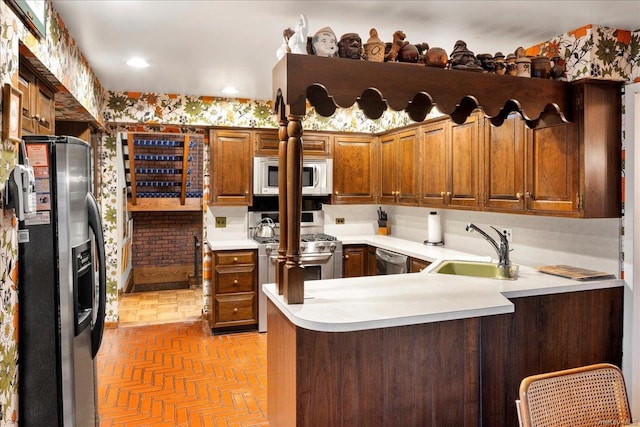 kitchen featuring a kitchen breakfast bar, kitchen peninsula, sink, and stainless steel appliances