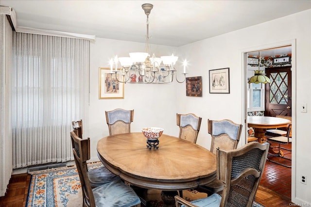 dining room with dark parquet flooring and a chandelier