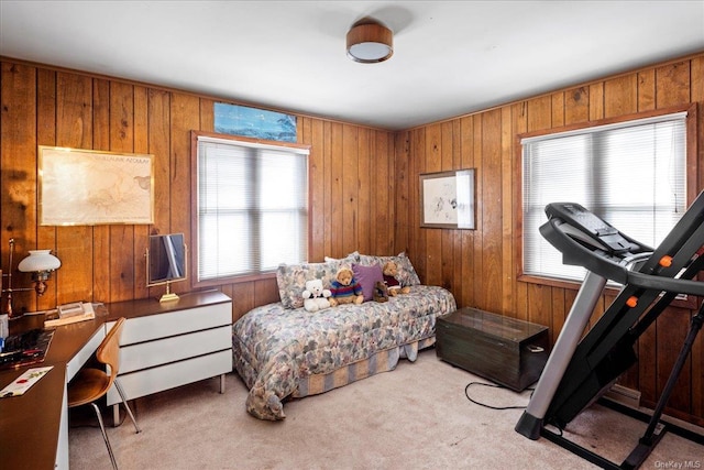 carpeted bedroom featuring wood walls and multiple windows