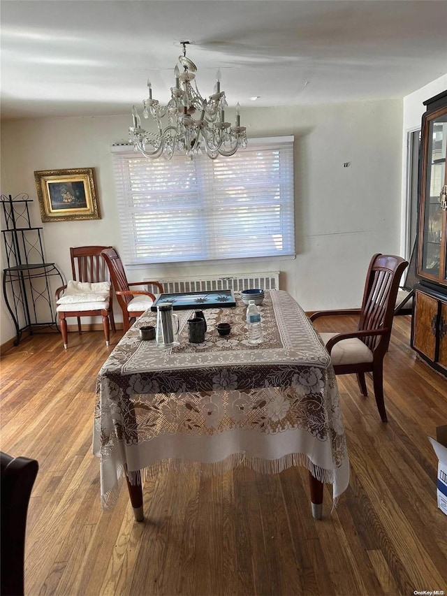 dining space featuring hardwood / wood-style flooring, a notable chandelier, and a wealth of natural light