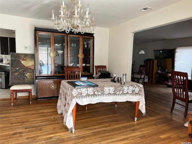 dining room featuring hardwood / wood-style floors and an inviting chandelier