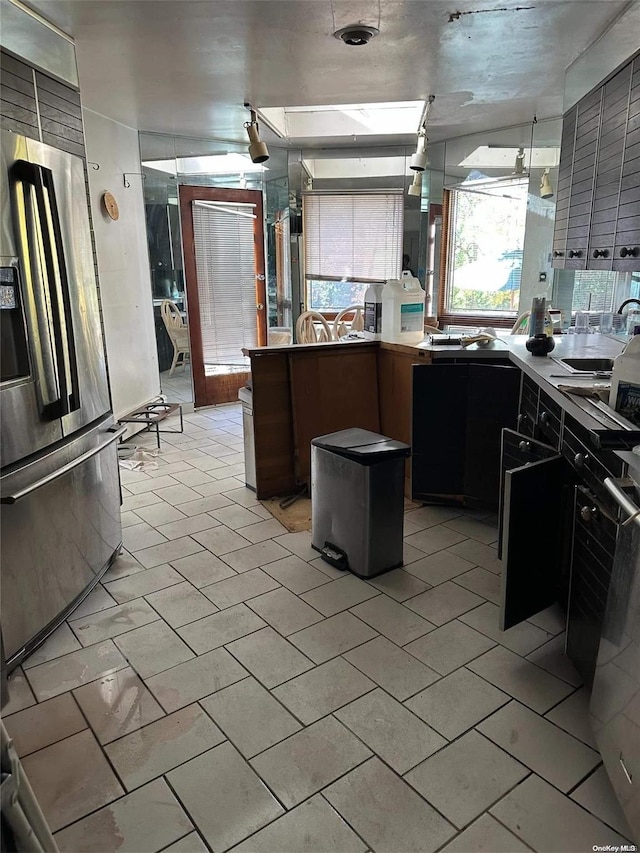 kitchen with sink and stainless steel refrigerator with ice dispenser