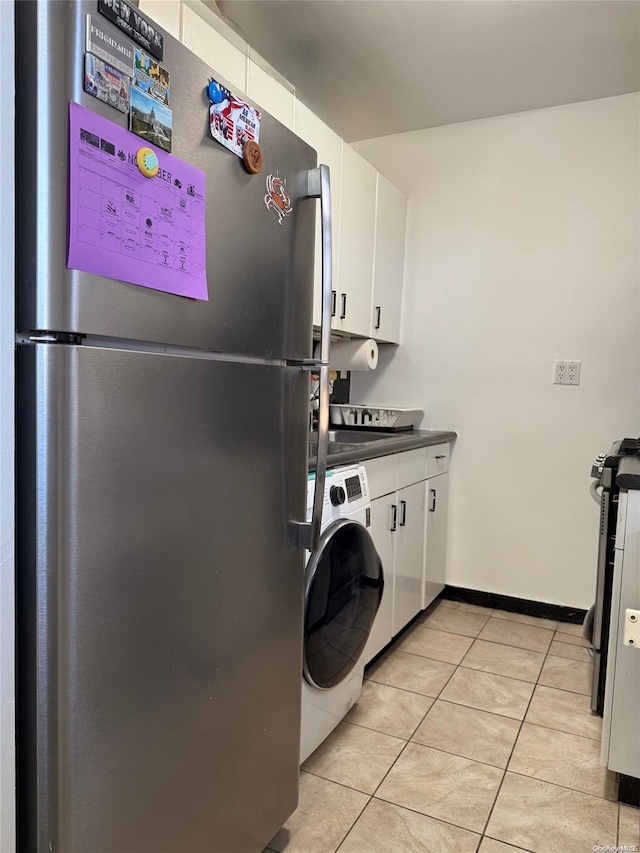 laundry area with washer / clothes dryer and light tile patterned floors