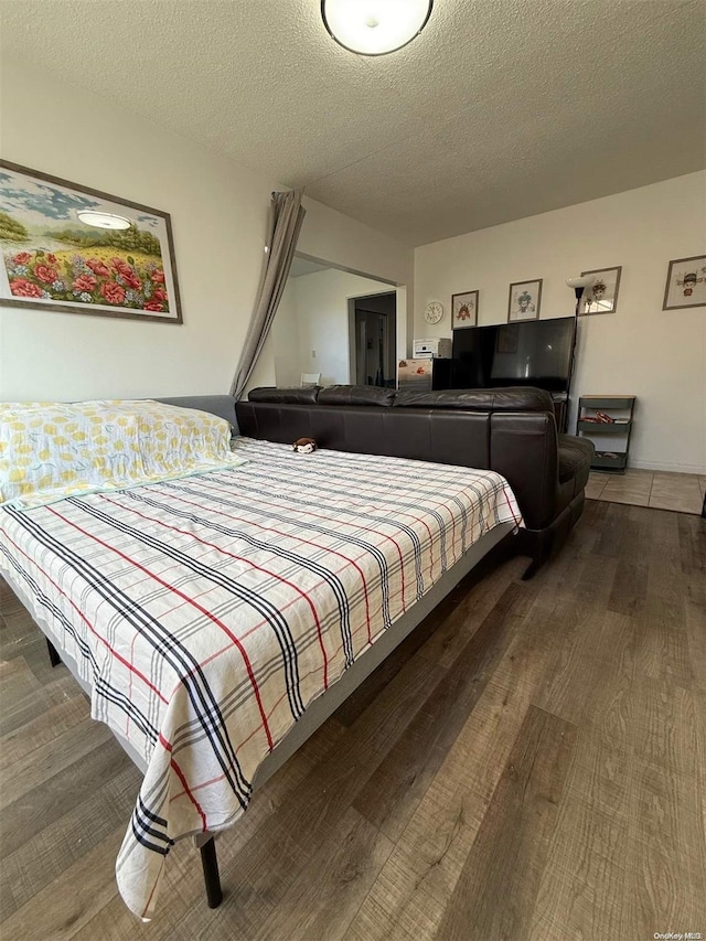 bedroom with hardwood / wood-style floors and a textured ceiling