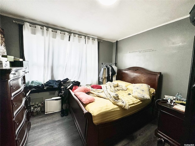 bedroom featuring ornamental molding and dark wood-type flooring