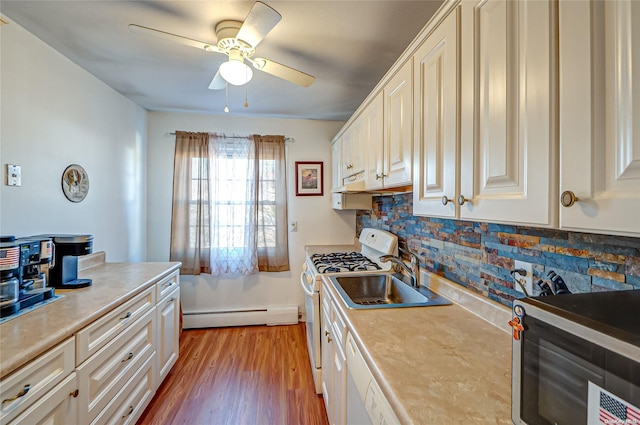 kitchen with sink, light hardwood / wood-style flooring, ceiling fan, baseboard heating, and gas range gas stove