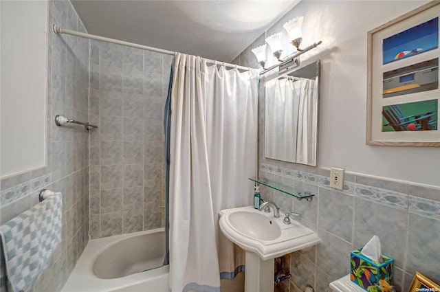 bathroom featuring tile walls, sink, and shower / bath combo