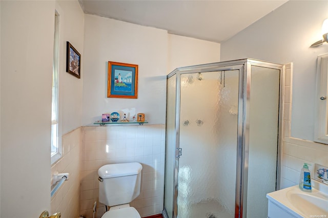 bathroom featuring vanity, toilet, walk in shower, and tile walls