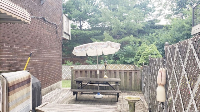 wooden deck featuring a grill