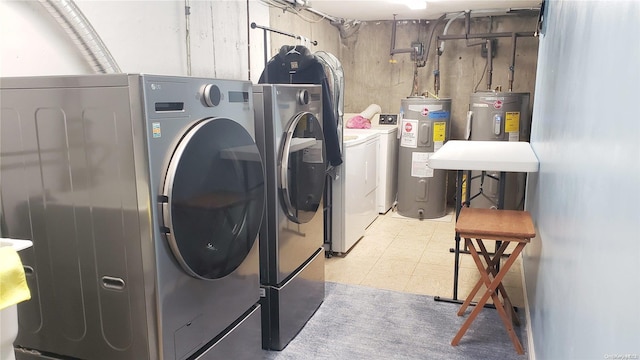 clothes washing area featuring separate washer and dryer and water heater