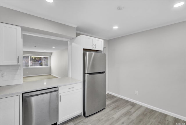 kitchen featuring white cabinets, stainless steel appliances, tasteful backsplash, and light hardwood / wood-style floors