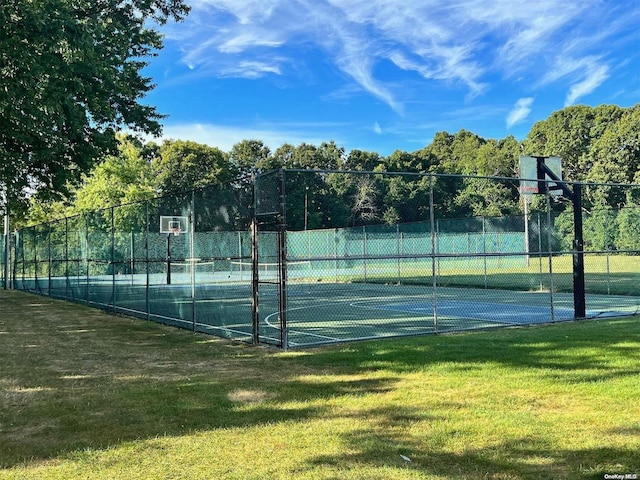 view of sport court featuring a lawn and basketball court