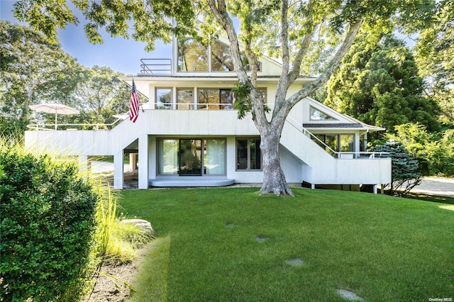 back of property featuring a yard and a balcony