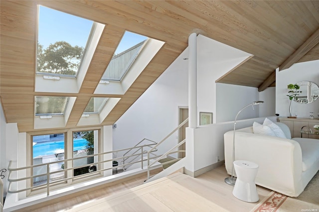 living room featuring lofted ceiling with skylight and wood ceiling