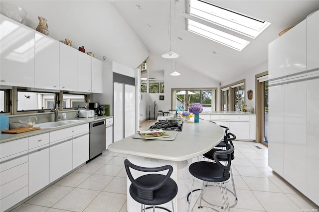 kitchen featuring a skylight, white cabinets, sink, high vaulted ceiling, and dishwasher