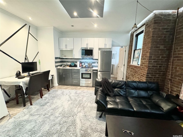 kitchen featuring white cabinetry, pendant lighting, decorative backsplash, appliances with stainless steel finishes, and ornamental molding