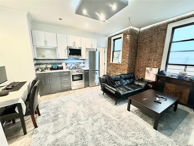 interior space with a healthy amount of sunlight, decorative backsplash, white cabinetry, and stainless steel appliances