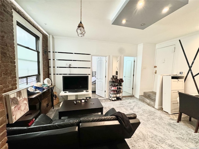 living room featuring plenty of natural light, brick wall, and ornamental molding