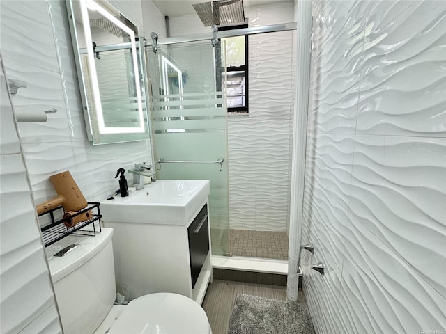 bathroom featuring walk in shower, vanity, tile walls, and toilet