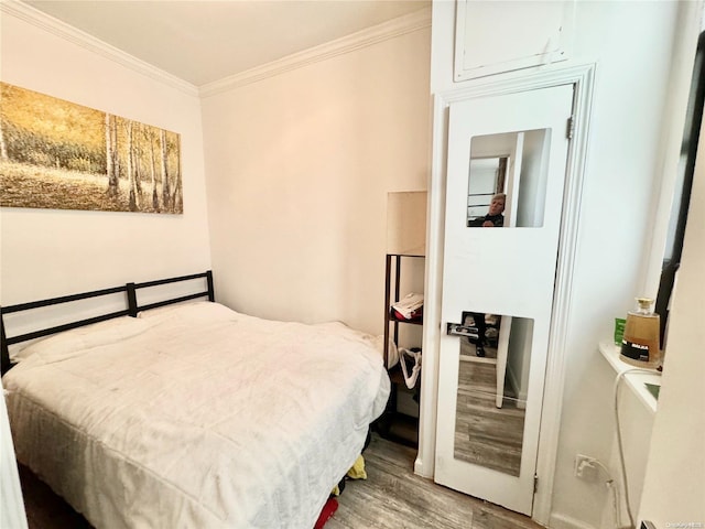 bedroom with wood-type flooring and crown molding