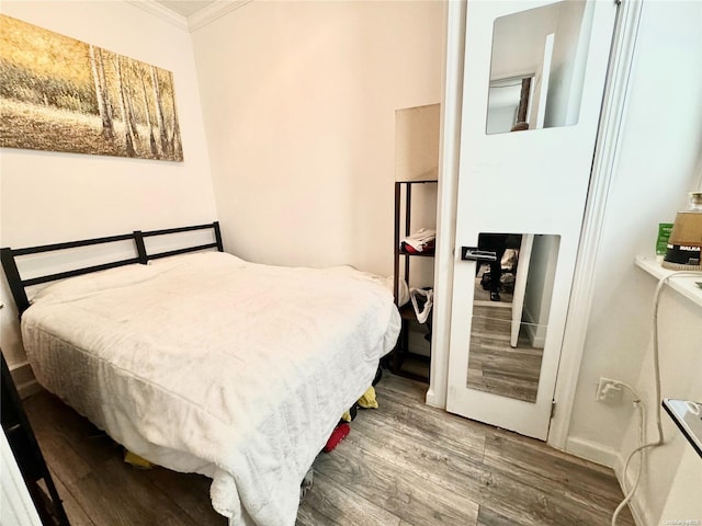 bedroom with wood-type flooring and crown molding