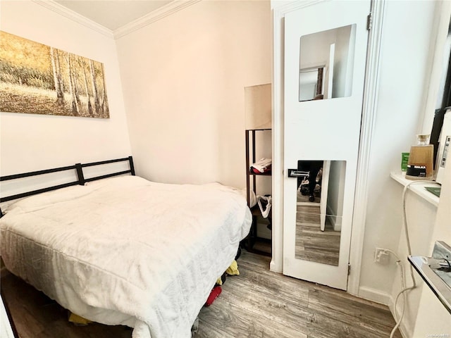 bedroom with wood-type flooring and ornamental molding