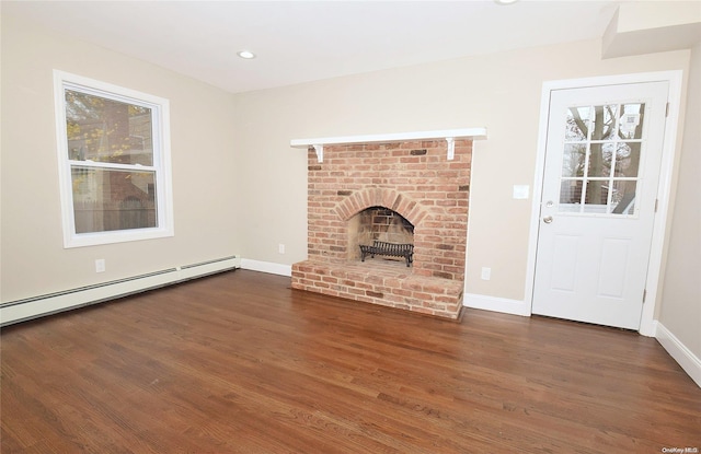 unfurnished living room with a fireplace, dark hardwood / wood-style floors, and baseboard heating