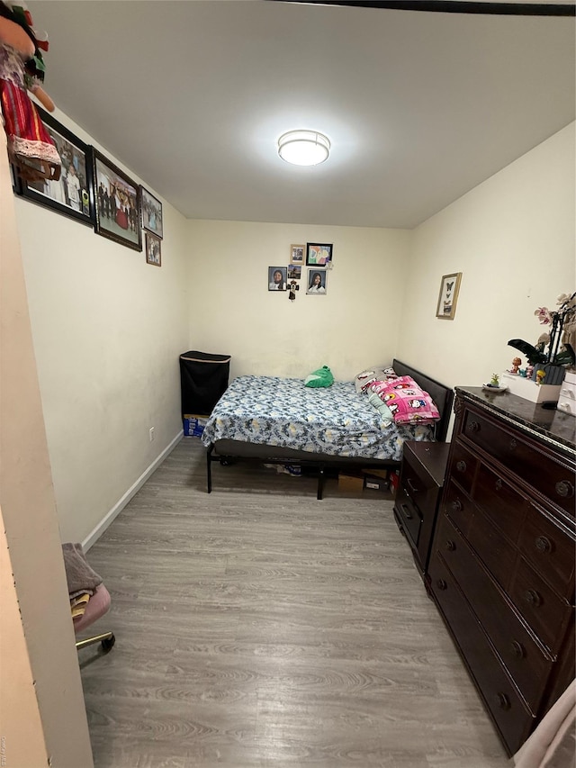 bedroom with baseboards and wood finished floors