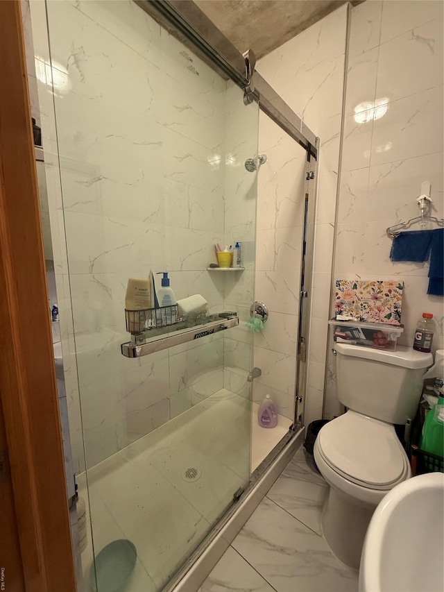 bathroom with marble finish floor, a shower stall, and toilet